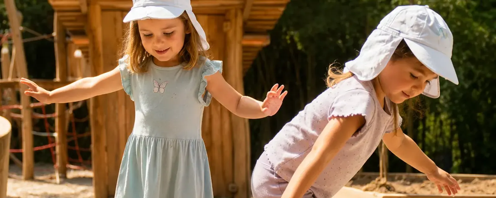 Zwei Mädchen spielen auf dem Spielplatz der Kita Bärlis